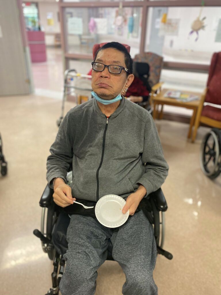 image of a man in a wheelchair holding a paper plate and fork