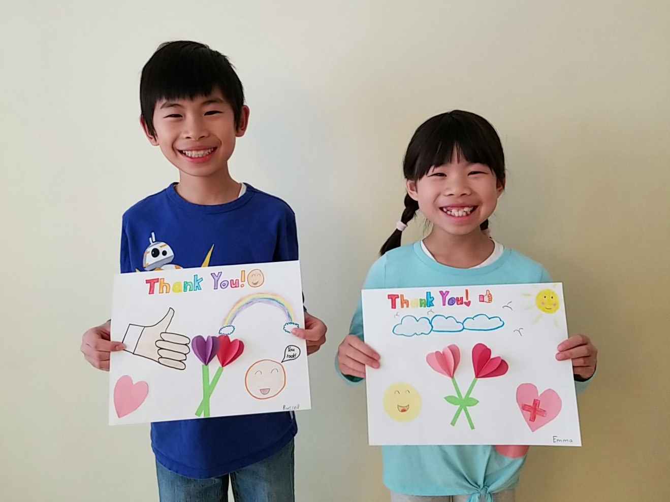 Russell and Emma Ng holding their signs of encouragement for Yee Hong staff